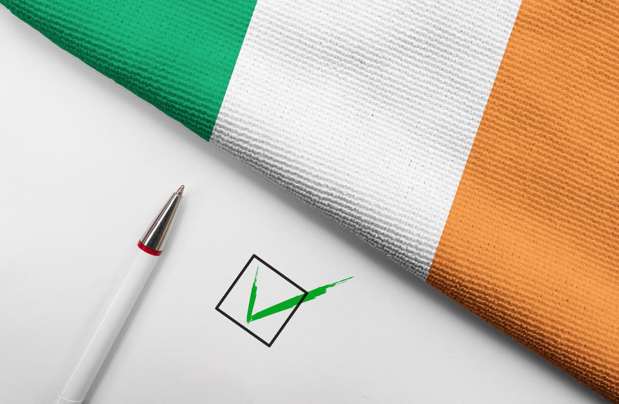 Irish flag next to pen and completed checkbox, symbolizing the completion and approval of the new VIF form process in Ireland.